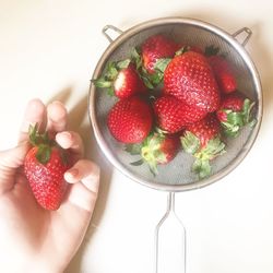 Close-up of hand holding strawberries