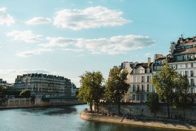 Buildings in city against cloudy sky