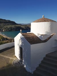 Built structure in sea against clear blue sky