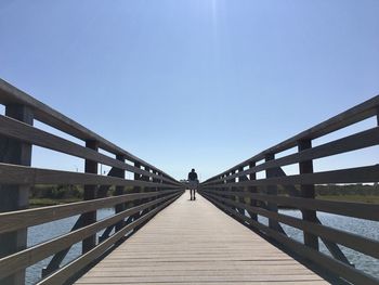 Full length of man walking on pier against sky