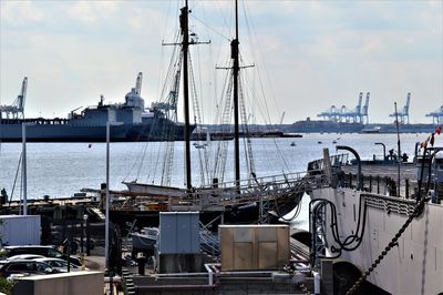 Sailboats moored at harbor