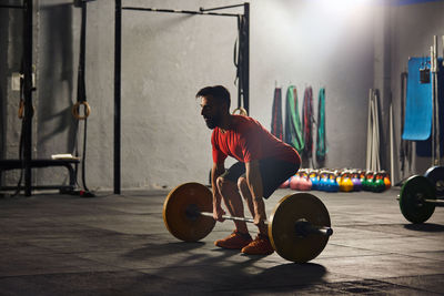 Full length of young man sitting on wall