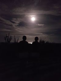 Silhouette boy against sky at night