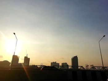 Silhouette buildings against sky during sunset