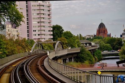 Railroad tracks amidst buildings in city against sky