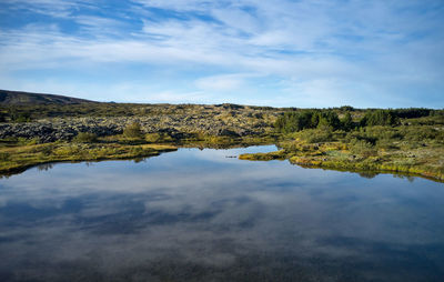 Idyllic landscape of lake with crystal tranquil water against gently sloping hill