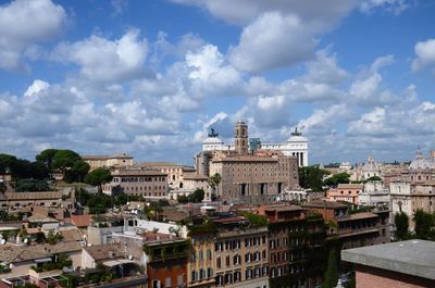 Scenic view of residential district against cloudy sky