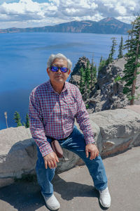 Full length of man sitting on rock