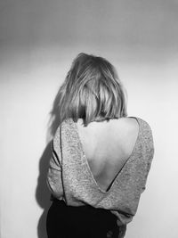 Rear view of woman standing against white background