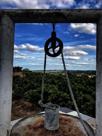 Close-up of metal hanging against sky