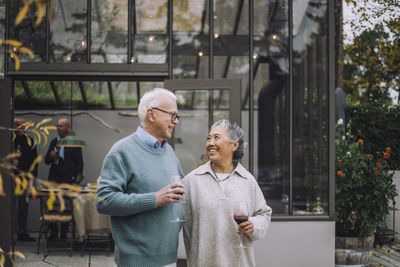 Male and female retired friends talking to each other at dinner party