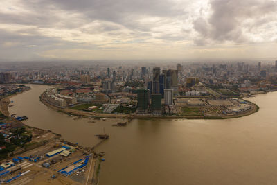 High angle view of buildings in city against cloudy sky