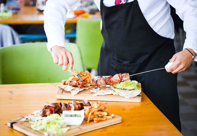 Midsection of man preparing food at restaurant