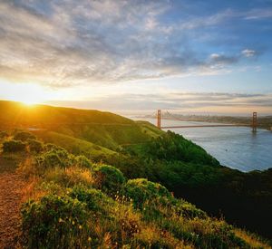 Scenic view of suspension bridge against cloudy sky