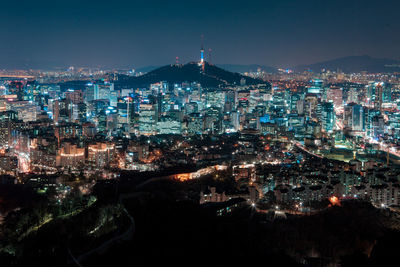 Illuminated cityscape against sky at night