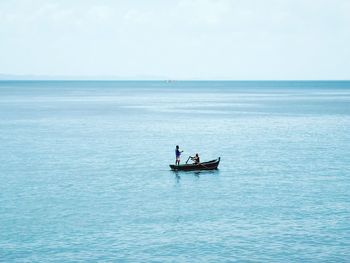 Men in sea against sky