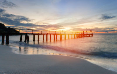 Pier on sea against sky during sunset