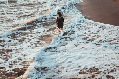 Full length of woman standing on shore at beach