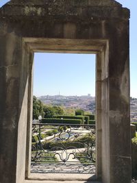 Plants seen through window of old building against clear sky