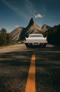 Road by mountain against sky