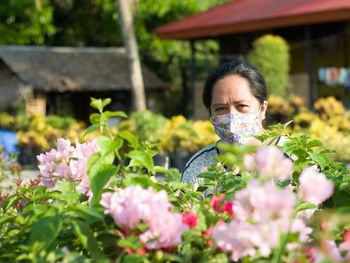 Portrait of woman with pink flowering plants