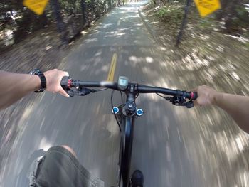 Cropped image of man riding bicycle on road