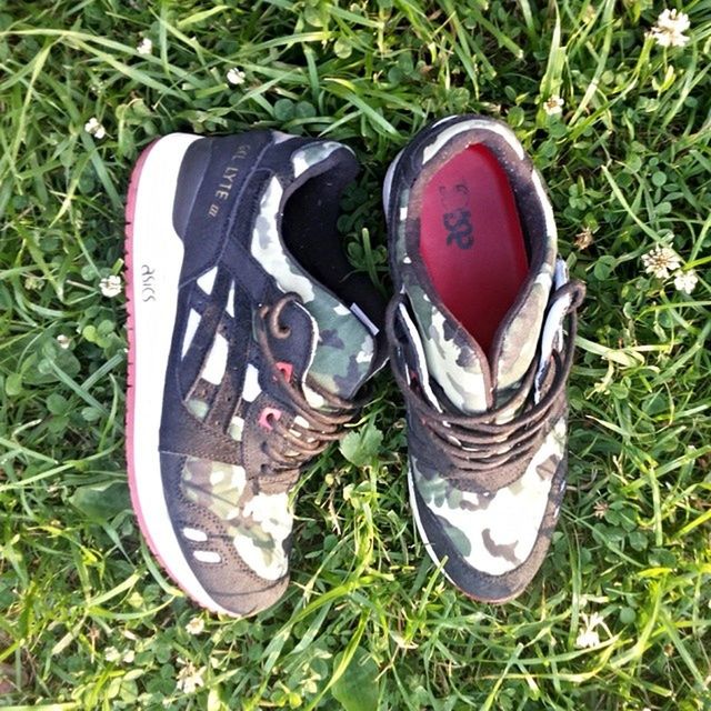 grass, shoe, high angle view, grassy, field, pair, still life, footwear, close-up, green color, abandoned, day, canvas shoe, ground, no people, outdoors, damaged, shoelace, directly above, two objects