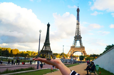 People holding tower against cloudy sky