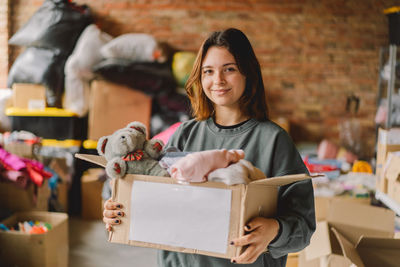 Volunteer teengirl preparing donation boxes for people.