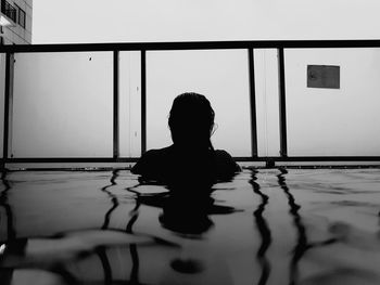 Rear view of silhouette woman in swimming pool