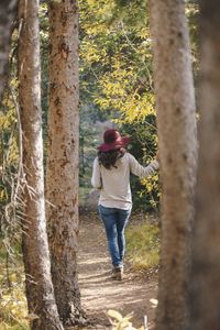 Full length of woman standing in forest during autumn