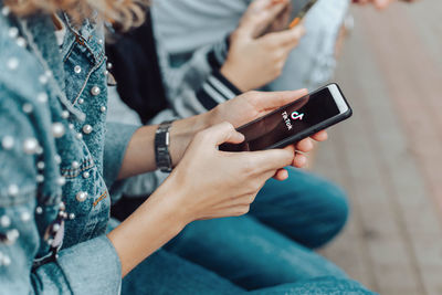 Midsection of man using mobile phone outdoors