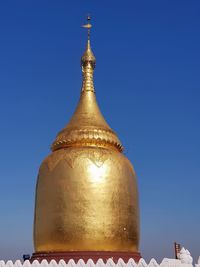 Low angle view of temple against building against clear blue sky