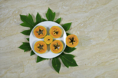High angle view of fruits and leaves on table