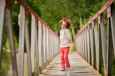 Full length of girl standing on footbridge