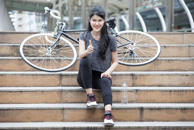 Full length portrait of woman with bicycle