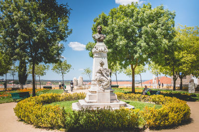 Statue by trees against sky