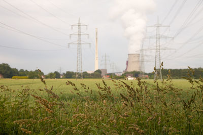 Electricity pylon on field against sky