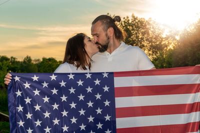 Couple with american flag. couple in love walking during sunset. usa independence day celebration