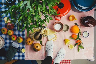 Low section of person standing by fruits and containers on table