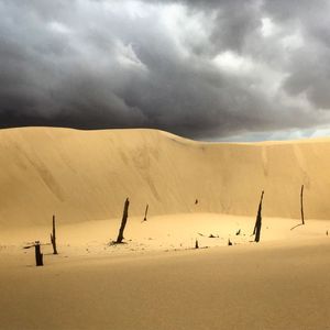 View of desert against cloudy sky