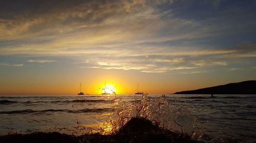 View of beach against cloudy sky during sunset