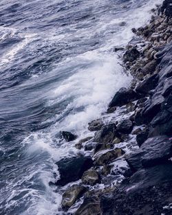 High angle view of waves breaking on rocks