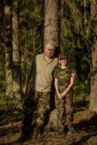 Portrait of young man standing in forest