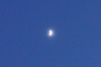 Low angle view of moon against blue sky