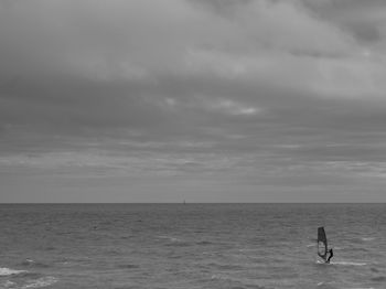 Man in sea against sky