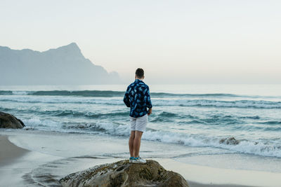 Man standing near the beach coastline.