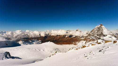 Snowcapped mountains against clear blue sky