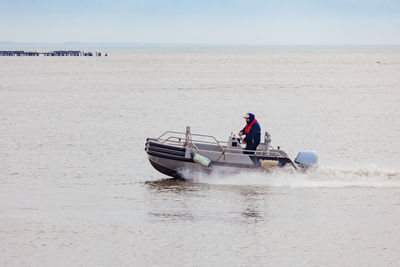 Man on boat at beach against sky