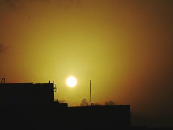 Silhouette of building against sky at sunset